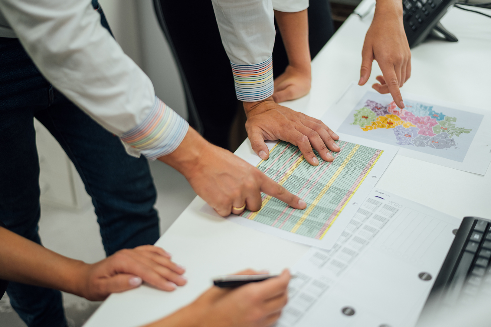 Teamwork bei der Analyse von Daten und Karten, um das Retailgeschäft der Zukunft zu gestalten. Mitarbeiter diskutieren am Schreibtisch über Strategien.