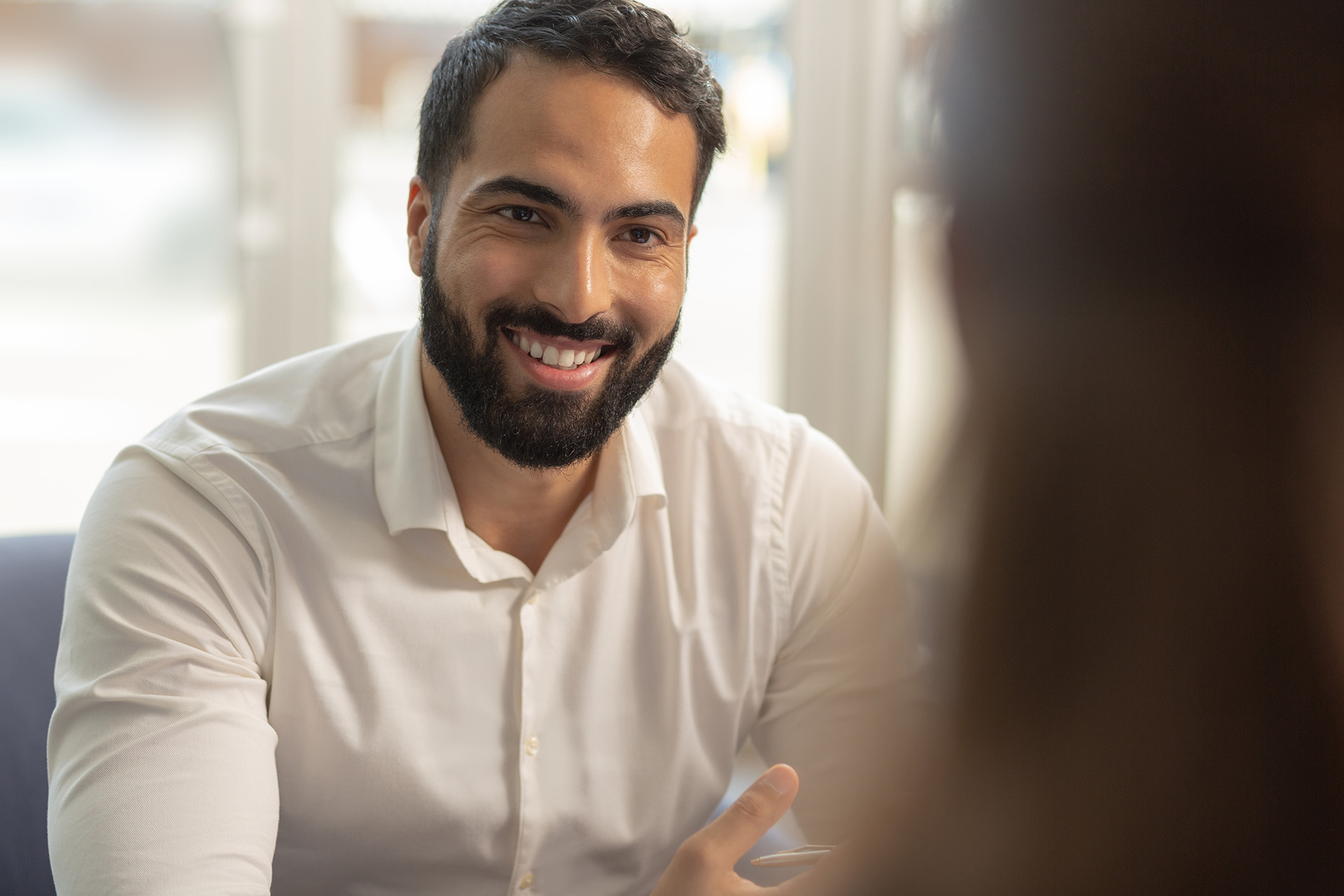 Ein lächelnder Mann in einem Vorstellungsgespräch, bereit, die Zukunft des Einzelhandels zu gestalten.  Karriere bei uns, um Omnichannel-Lösungen zu entwickeln.