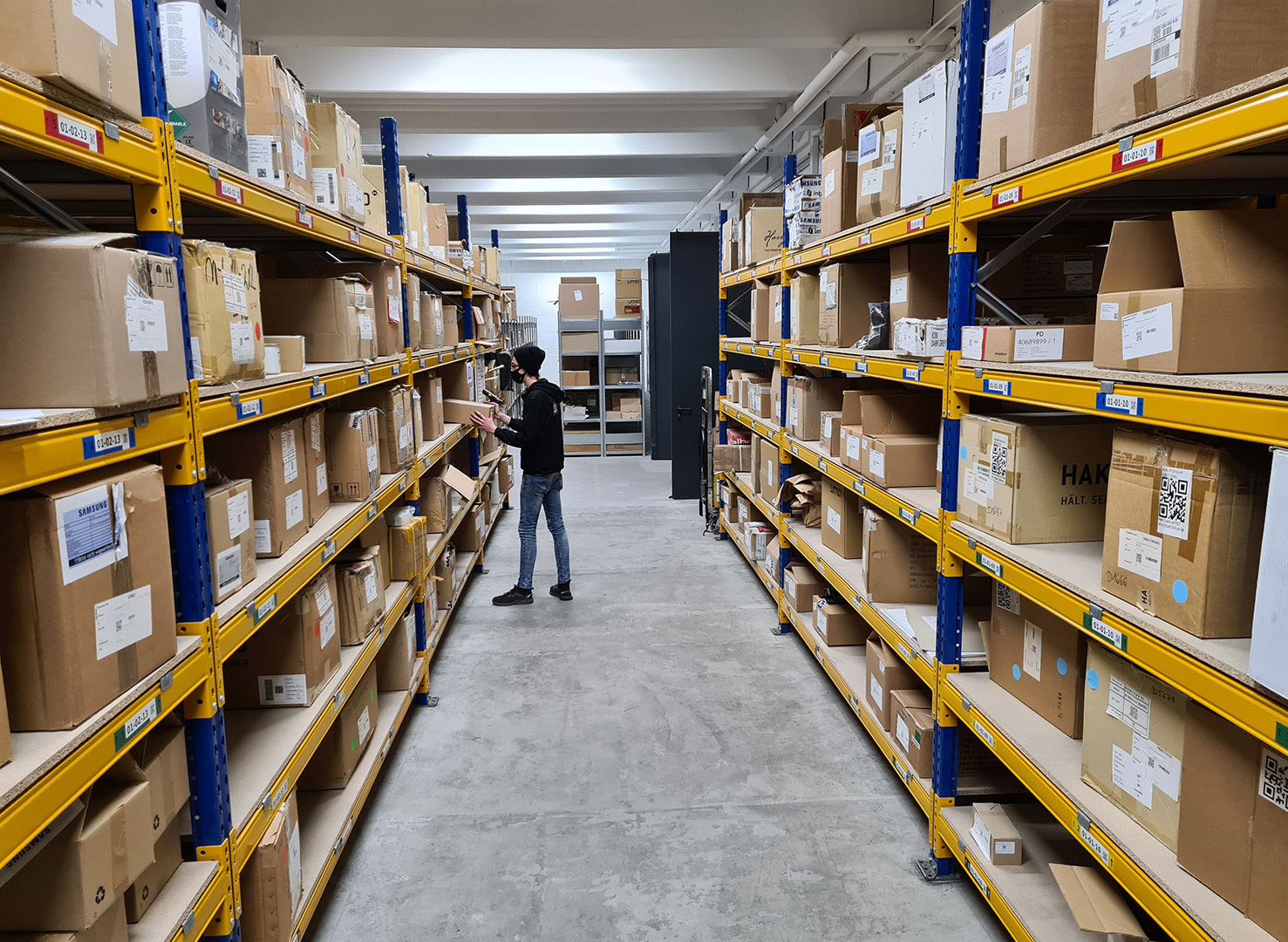 Mitarbeiter im Lager beim Kommissionieren von Waren, ein wichtiger Schritt für das Omnichannel-Retail-Geschäft. Das Bild zeigt die Logistik für eine nahtlose Omnichannel-Verknüpfung.