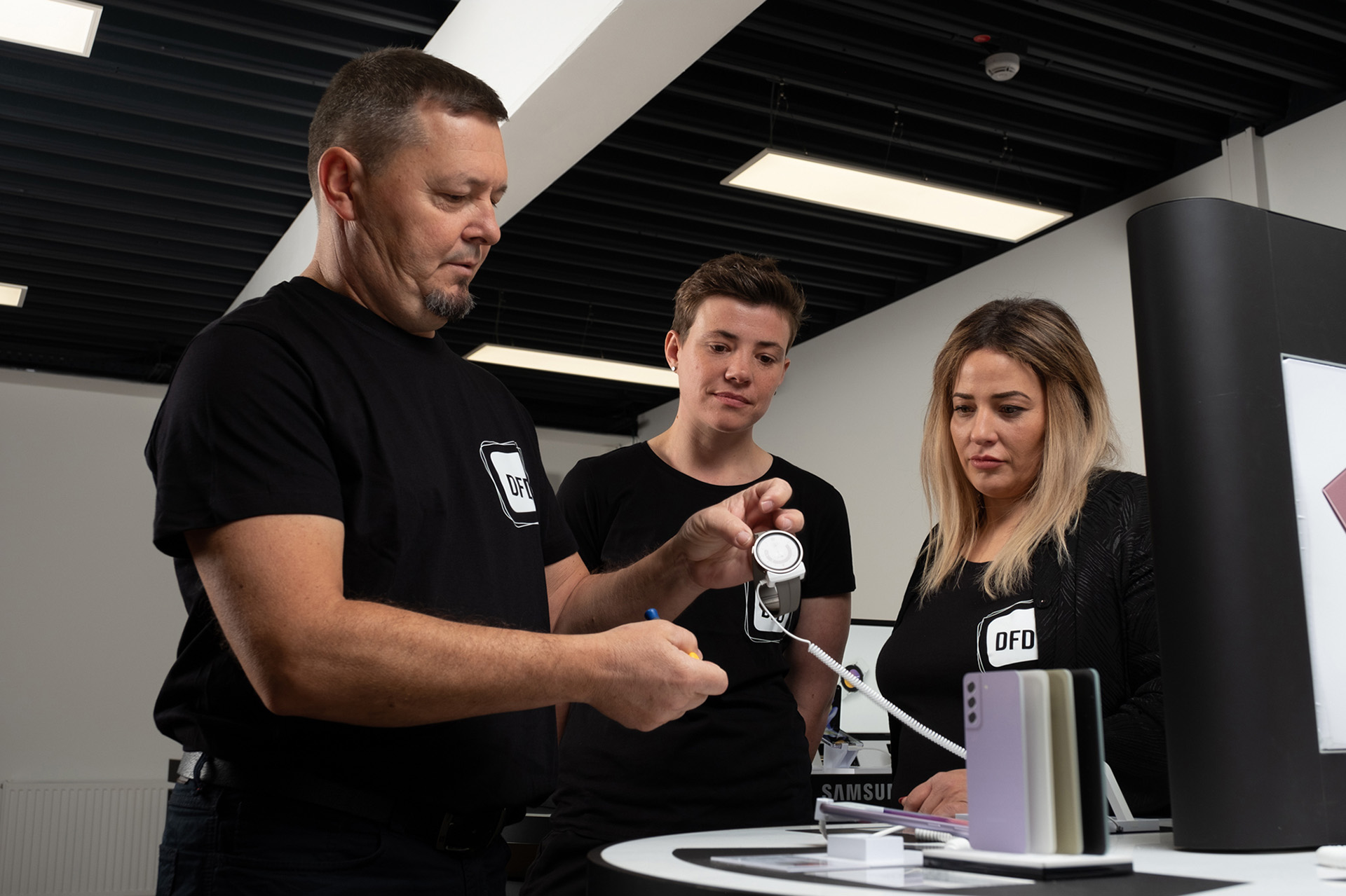Mitarbeiter von DFD im Gespräch über ein Produkt im Einzelhandel. Das Team arbeitet gemeinsam an der Zukunft des Retailgeschäfts.
