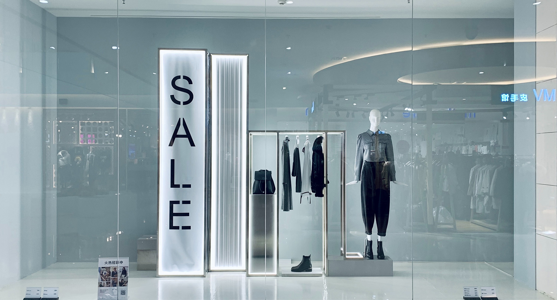 Schaufenster eines modernen Bekleidungsgeschäfts mit Sale-Hinweis und Mode-Präsentation. Das Bild zeigt eine stilvolle Omnichannel-Retail-Umgebung.