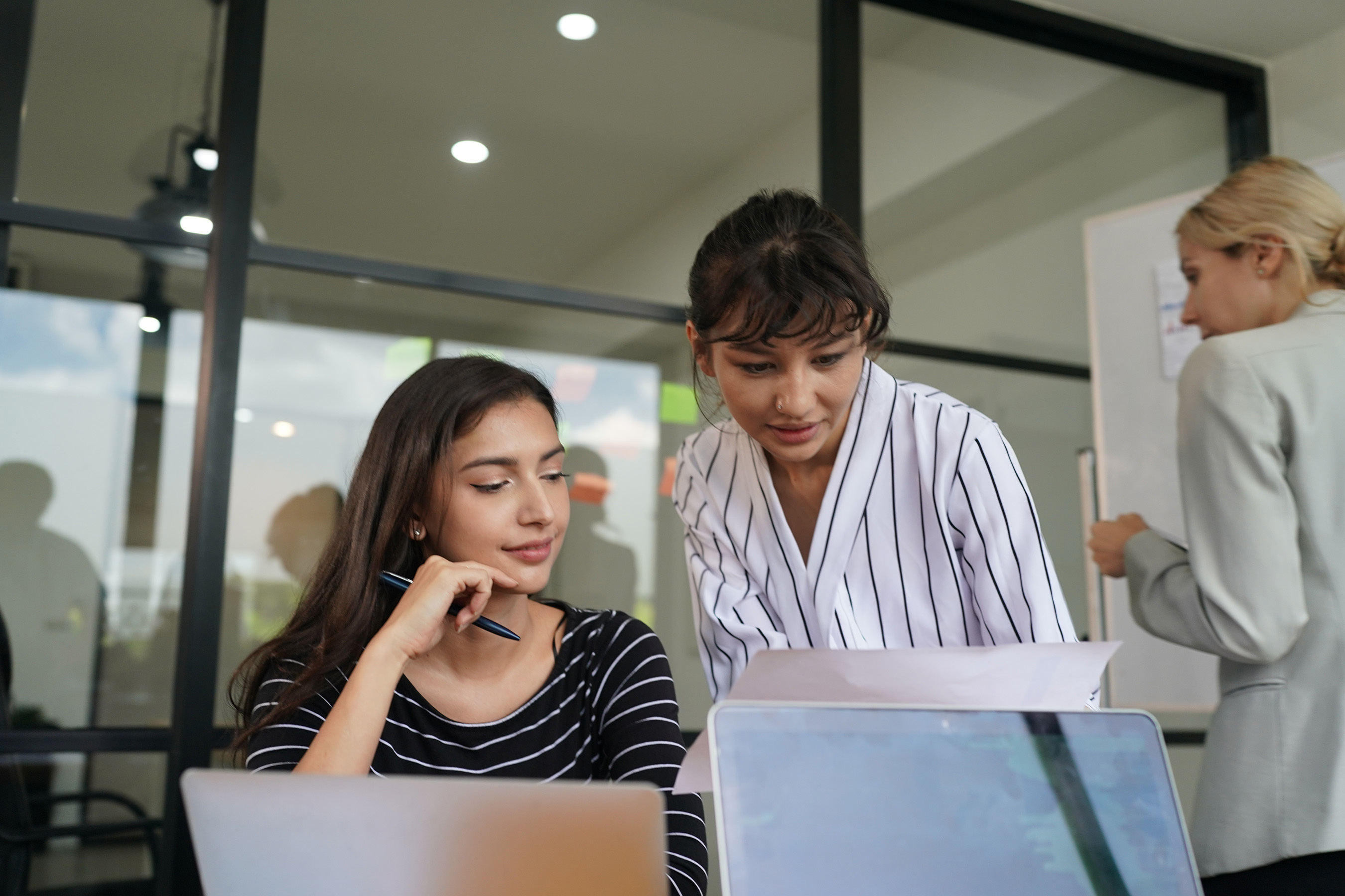 Team von Mitarbeitern arbeitet gemeinsam an einem Projekt, um das Retailgeschäft der Zukunft zu gestalten.  Die Mitarbeiter diskutieren und analysieren Daten, um den Mehrwert für Kunden zu maximieren.